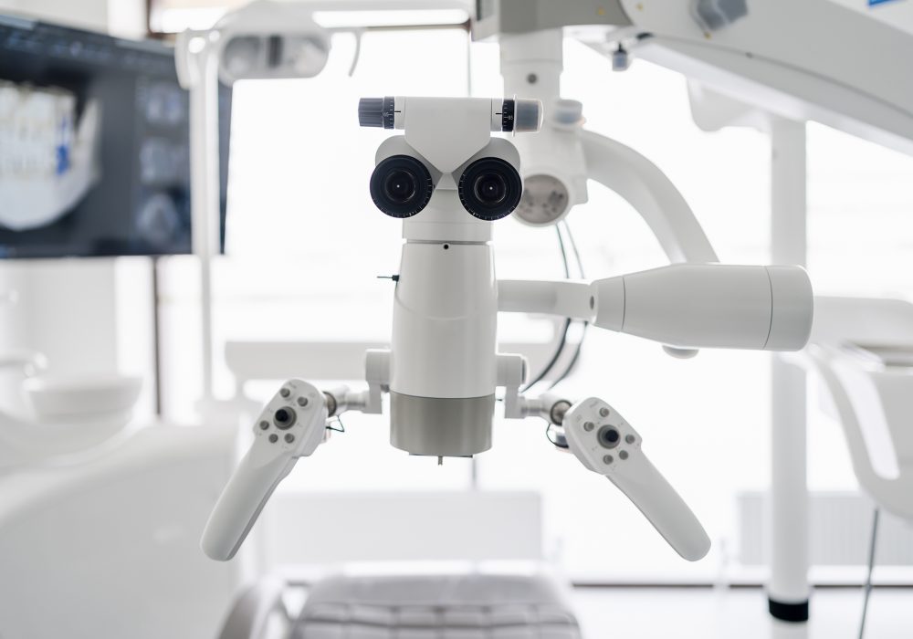 Interior of dental practice room with close up on microscope and dental scan on the display. Stomatology modern equipment