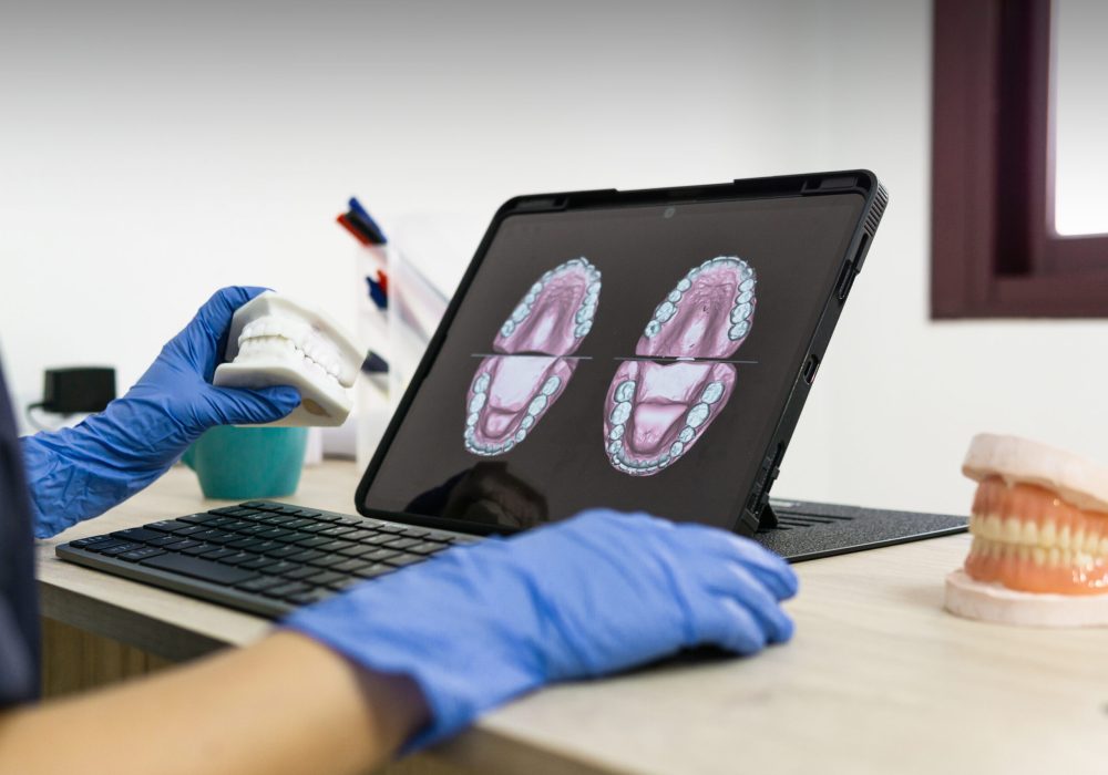 A dental technician designing a new dental prosthesis on the computer
